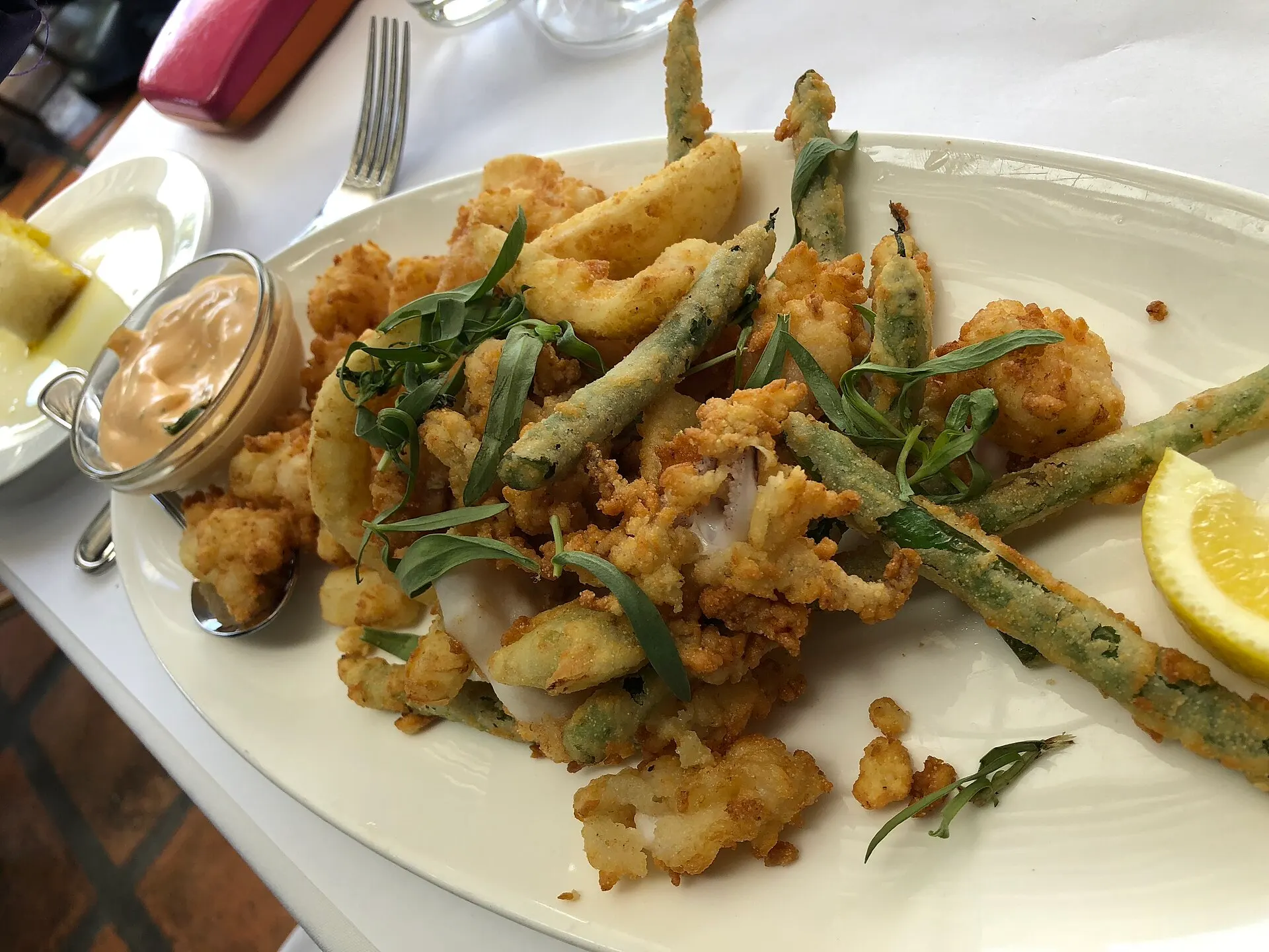 Fritto misto — a classic Ligurian plate of lightly-battered fried calamari, prawns and vegetables with lemon.
