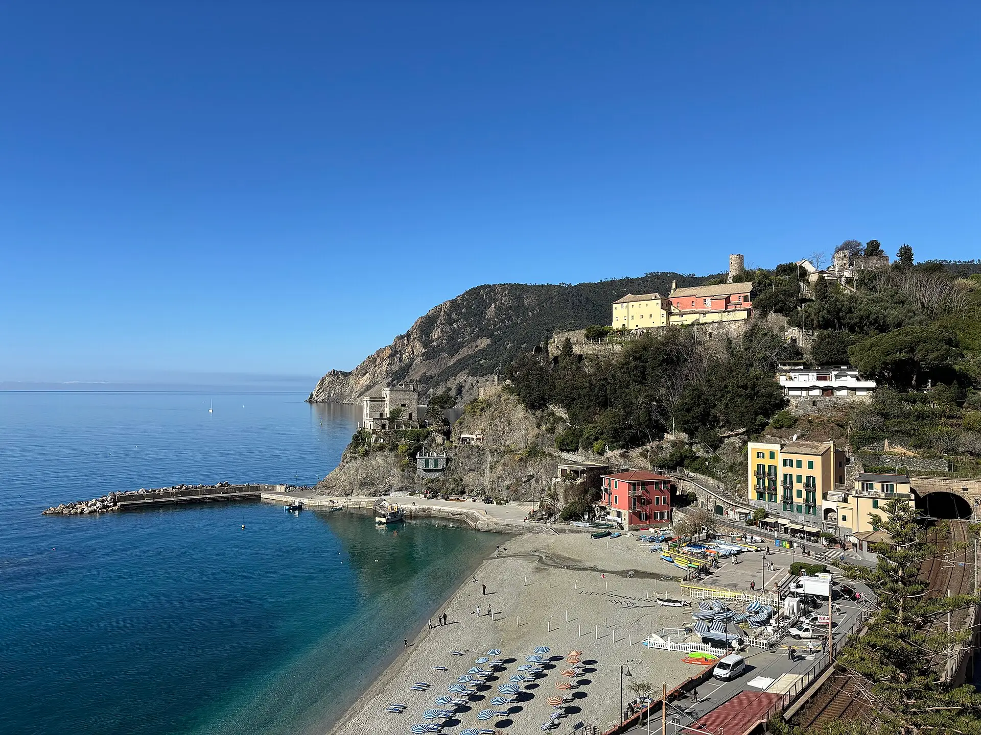 Monterosso al Mare beach — sandy crescent below the village headland and old watchtower, the largest beach in the Cinque Terre.