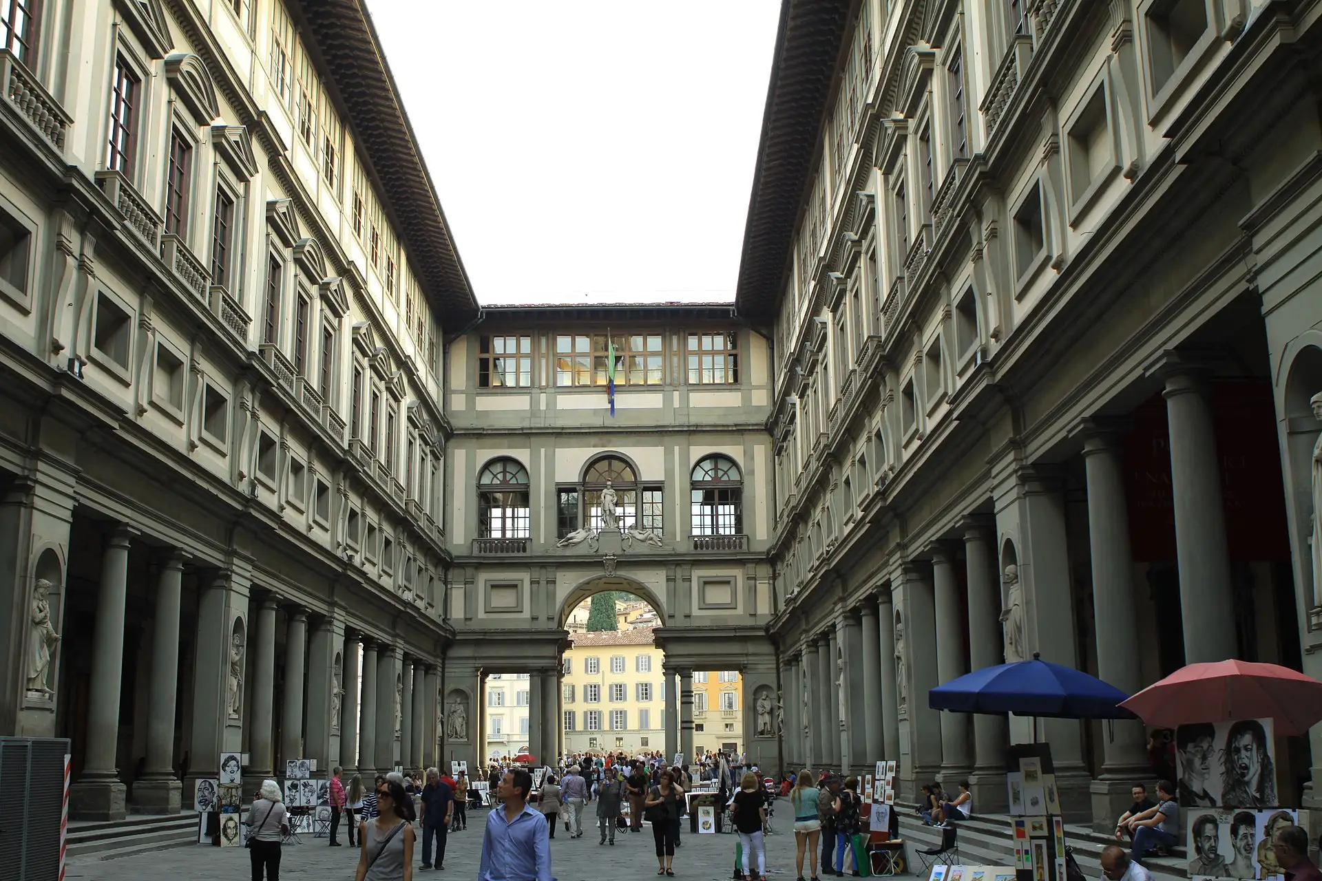 The Uffizi Gallery courtyard in Florence — the long colonnaded corridor framing a view down to the Arno.