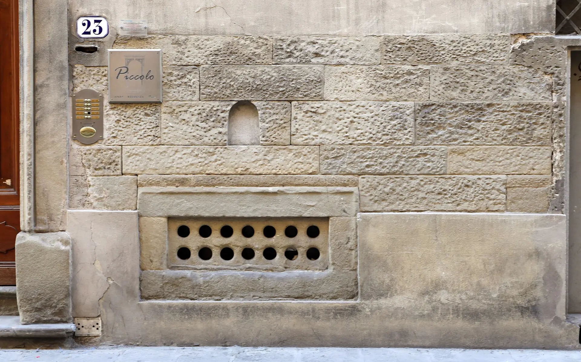 A buchetta del vino — one of the small arched wine windows in a Florence palazzo wall, where wine has been served since the Renaissance.